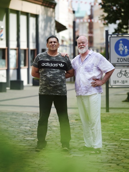 Ertun Sarkaya und Matthias Munko vor einer Fußgängerzone.