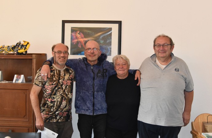 Gruppenfoto einer Gastfamilie mit drei Männern und einer Frau im Wohnzimmer