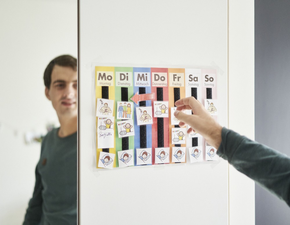 Ein junger man verschiebt Bilder auf einem Stundenplan.