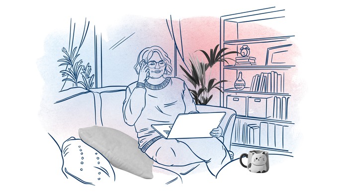 Eine Frau sitzt auf einem Sofa, telefoniert und hat einen Laptop auf dem Schoß.