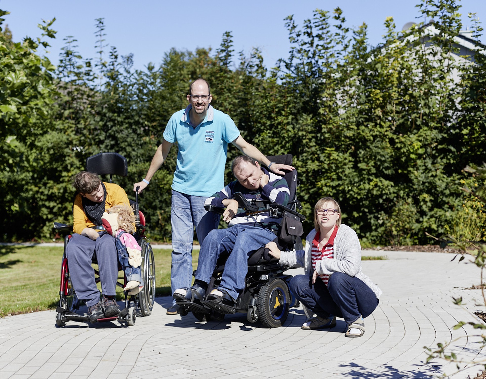 Eine Gruppe junger Menschen mit Behinderungen in einem Garten.
